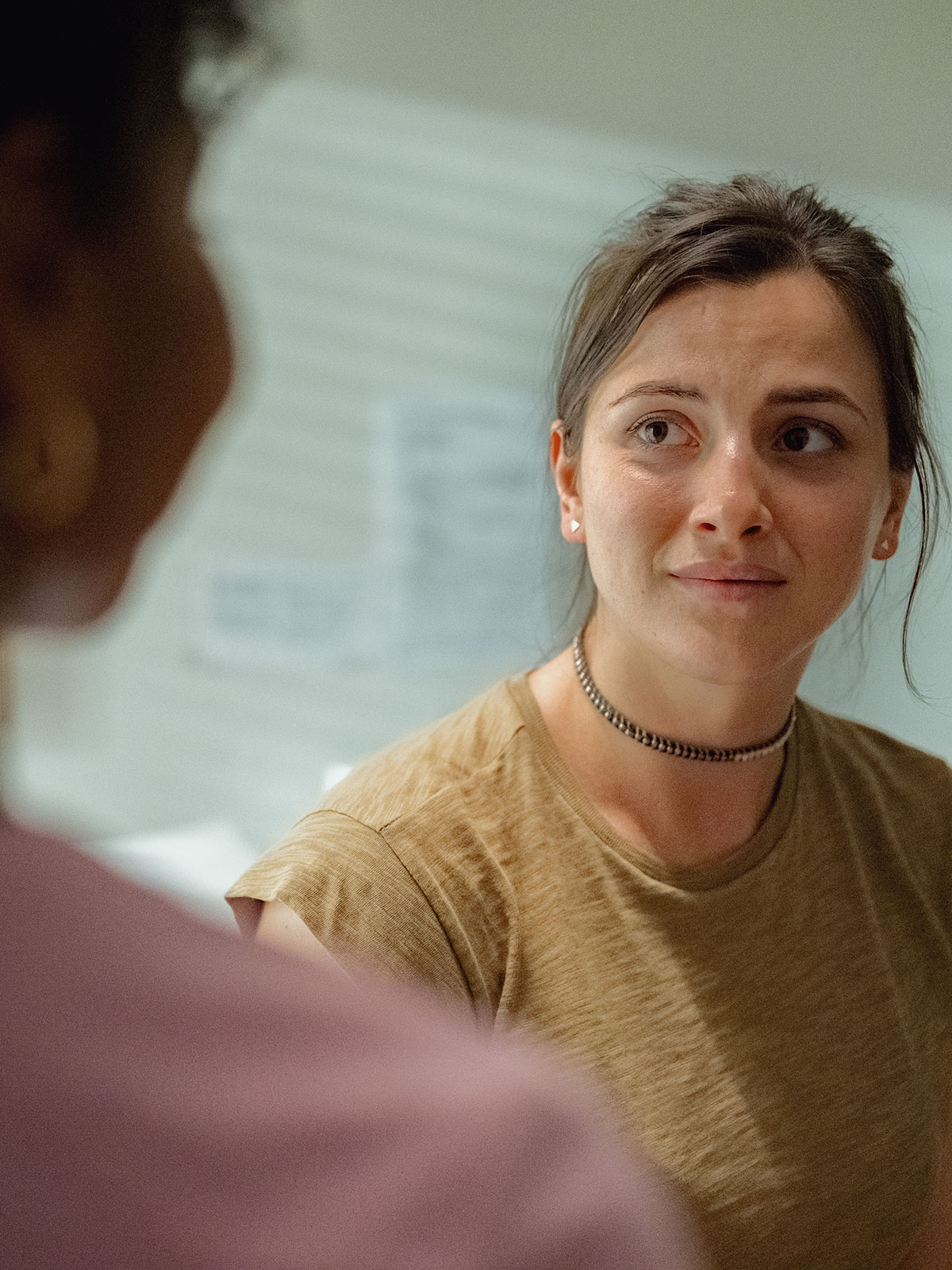 Concerned looking young woman looks to a healthcare provider