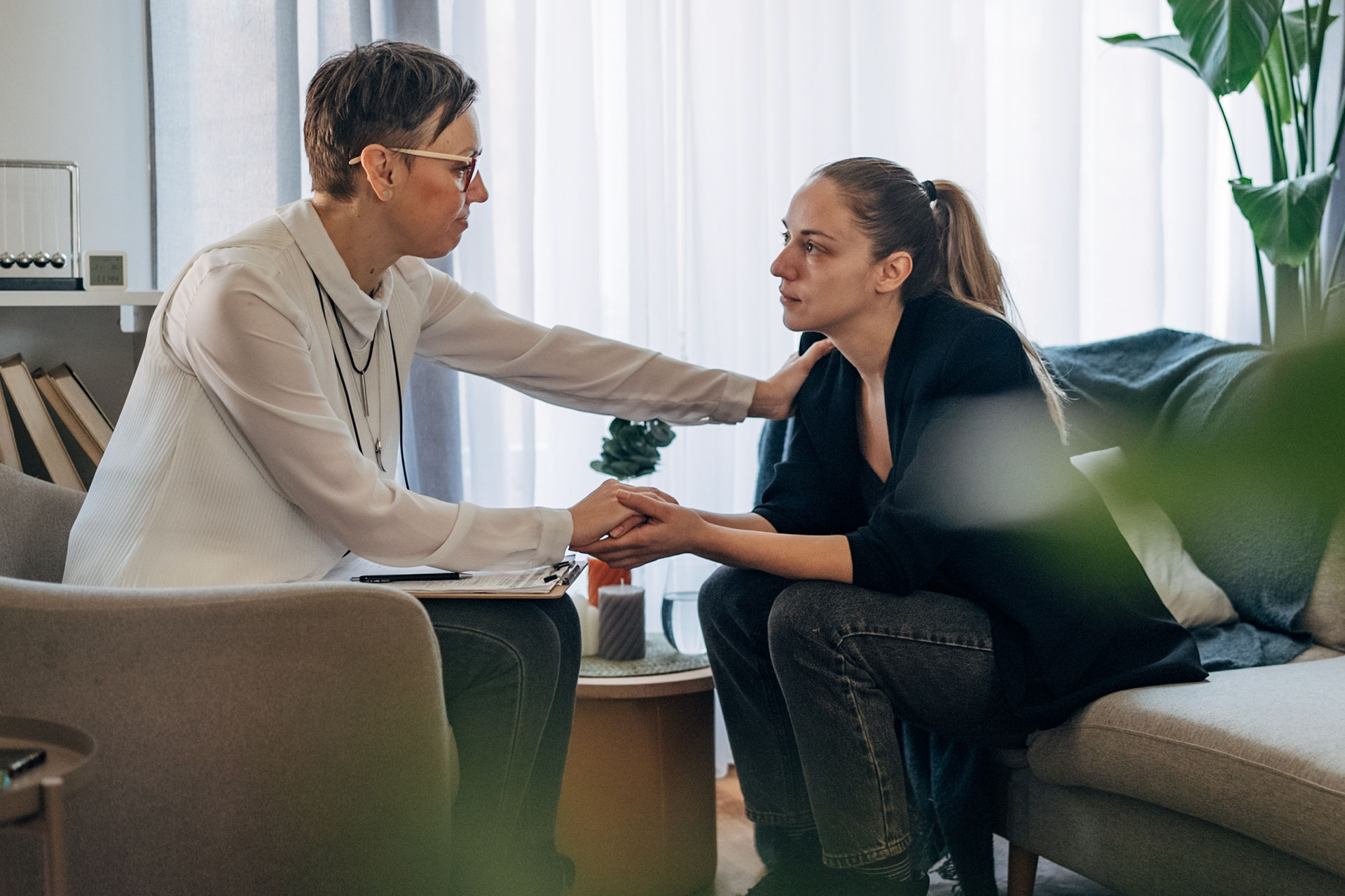A counselor comforts a concerned looking woman