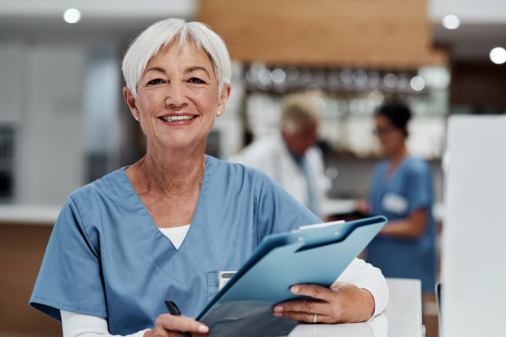 A medical worker smiling and holding a chart